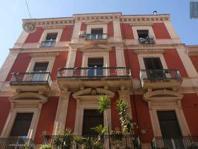 Foto 6. Ma al contrario, sempre su via Manzoni ecco porsi davanti a noi un imponente palazzo rosso e bianco tornato agli antichi splendori dopo un evidente restauro. Particolari sono le lesene che incorniciano le finestre a due ante, chiuse da timpani arrotondati 